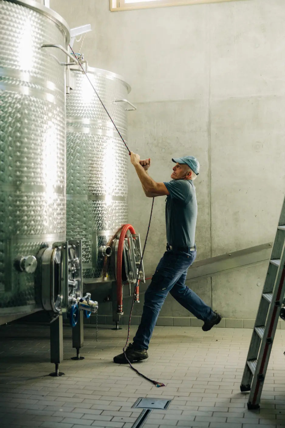 Winzer bei der Arbeit im Weinkeller des Weingut Marugg an Edelstahltanks.