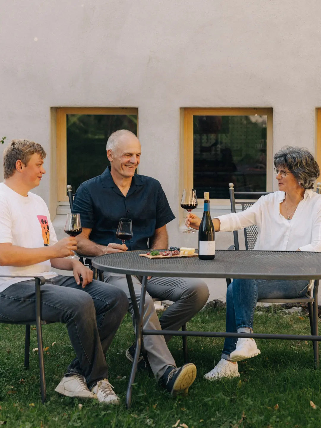 Daniel und Monika Marugg mit Mitarbeiter Thomas Bernhard bei einer Weindegustation im Aussenbereich